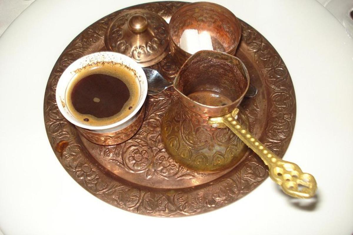 un piatto di rame con una tazza di caffè e un cucchiaio