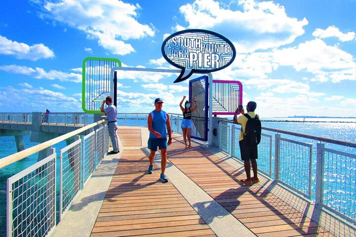 Un grupo de personas de pie en un muelle cerca del agua.