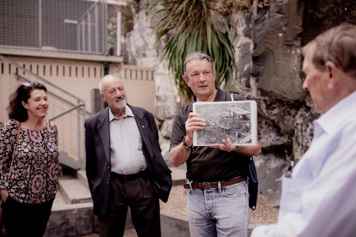 grupp inimesi, kes seisavad kaarti hoidva mehe ümber