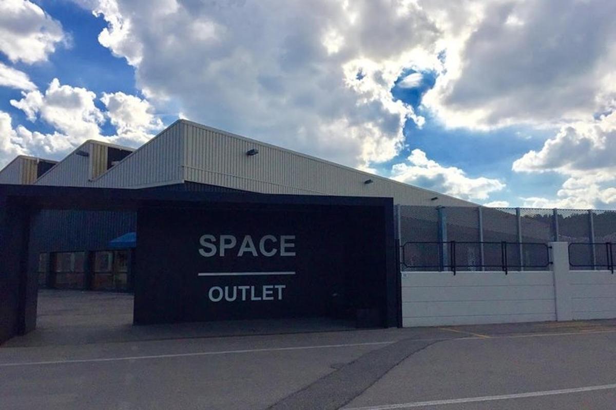 a building with a space outlet sign in front of it