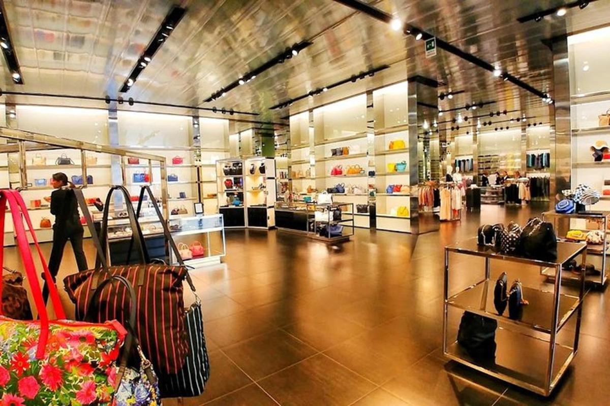 uma pessoa parada em um shopping com sacolas