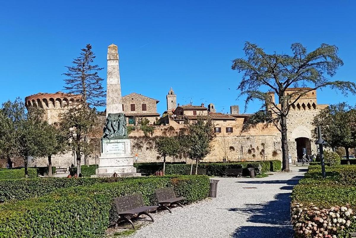 Un edificio con una estatua y bancos delante.