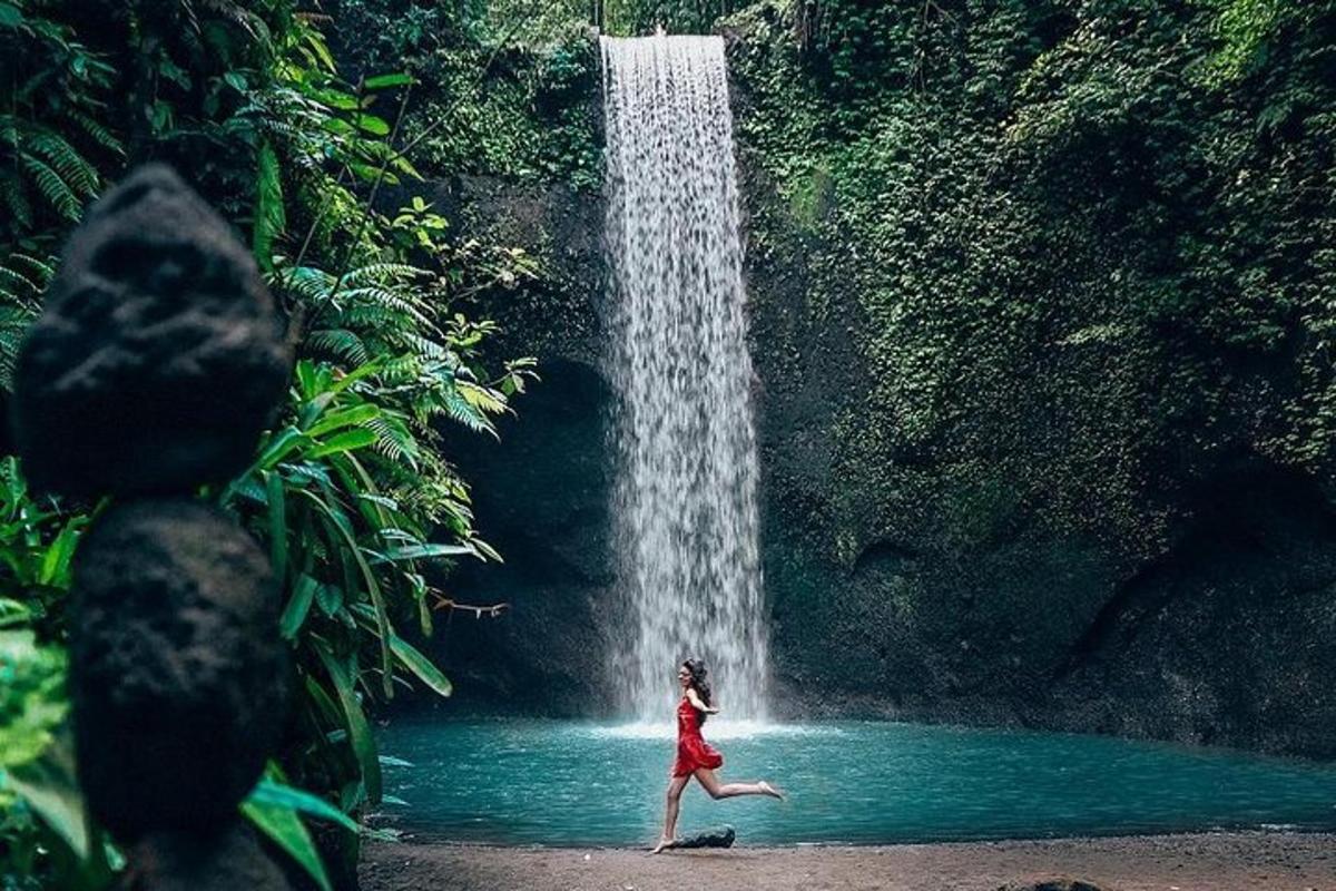 kona hlaupandi fyrir framan foss