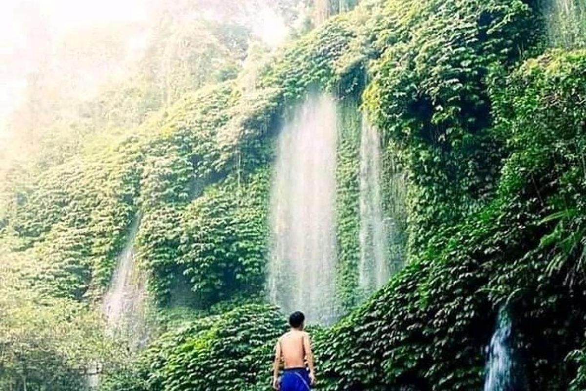 un uomo in piedi davanti a una cascata