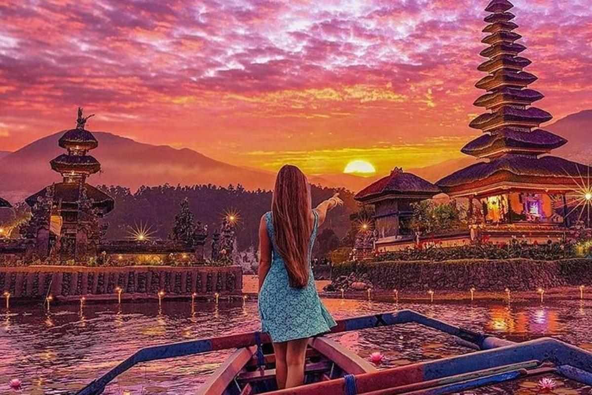 una donna in piedi su una barca che guarda il tramonto