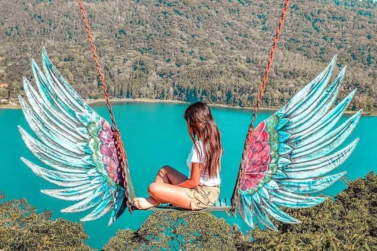 seorang wanita duduk di ayunan di atas danau
