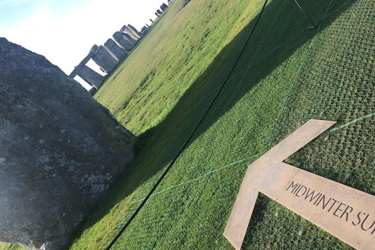 a sign on the side of a grass field