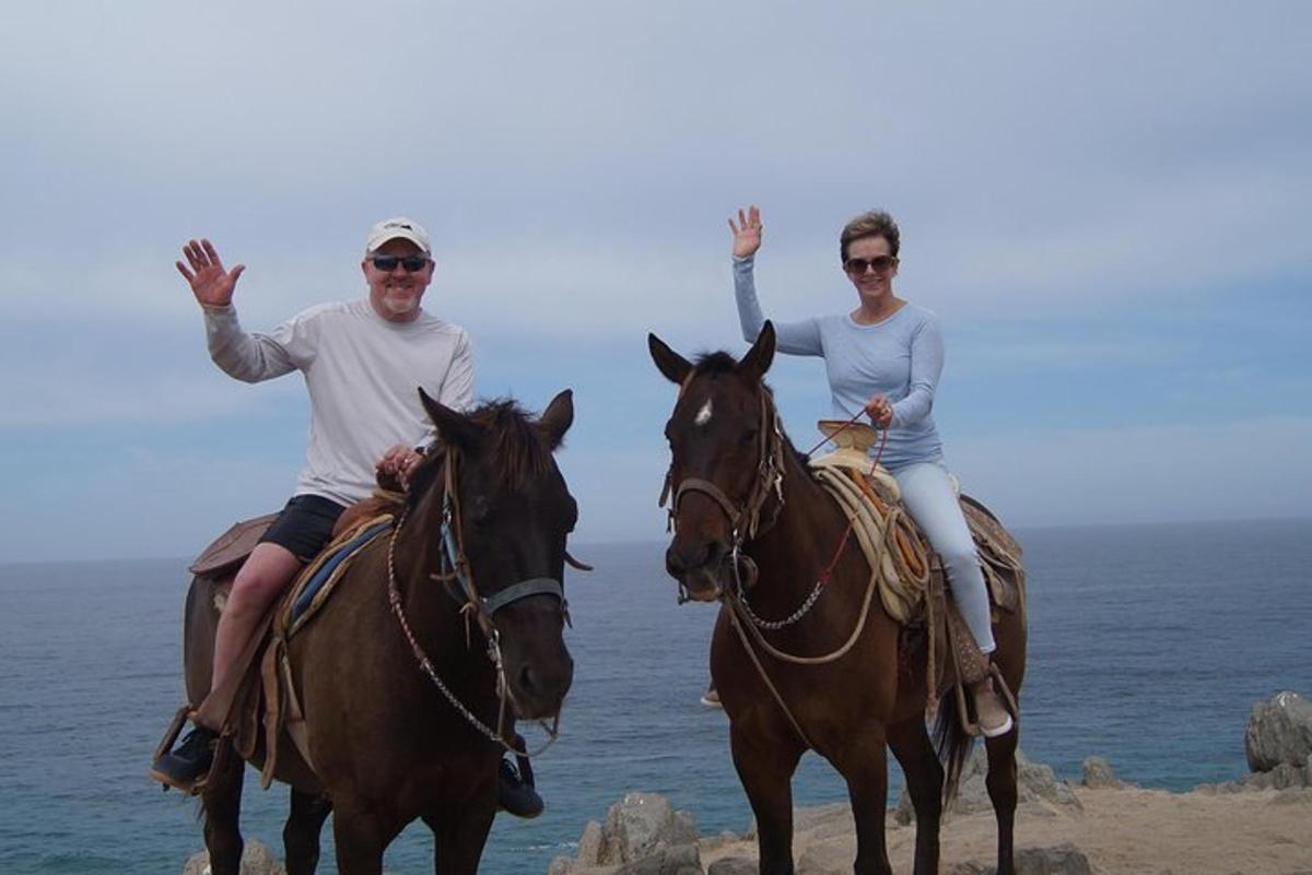 un uomo e una donna a cavallo sulla spiaggia