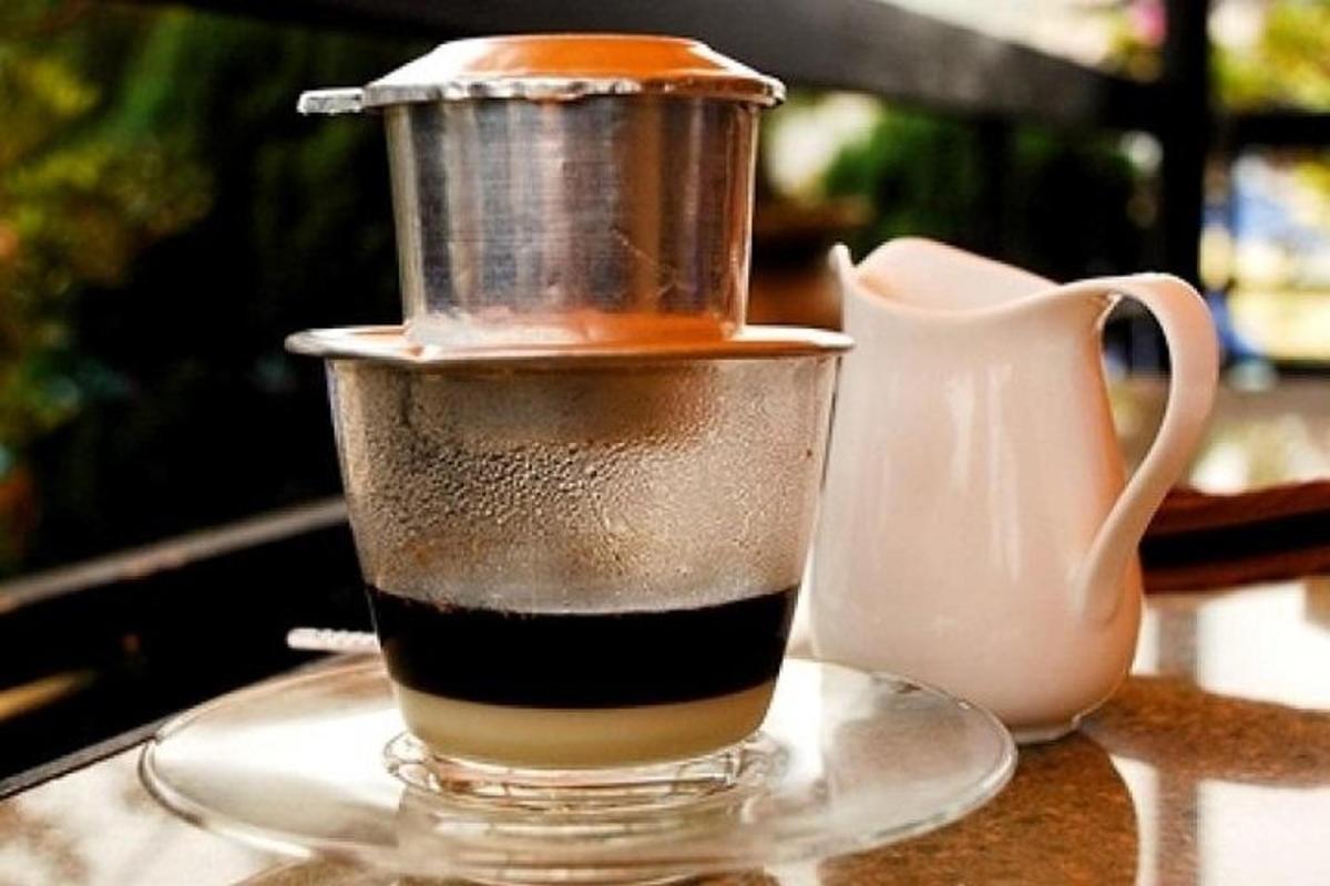 eine Tasse Kaffee auf einem Tisch neben einem Krug