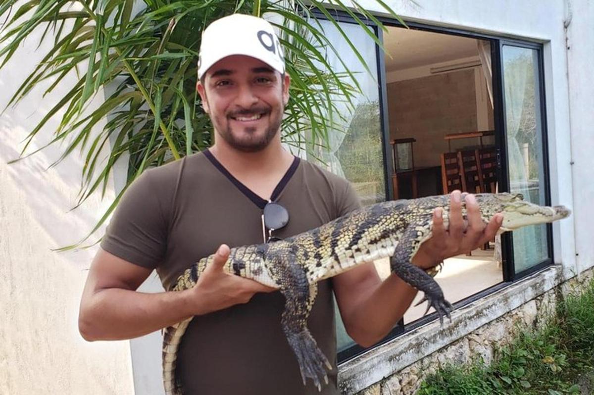 moški drži velikega aligatorja