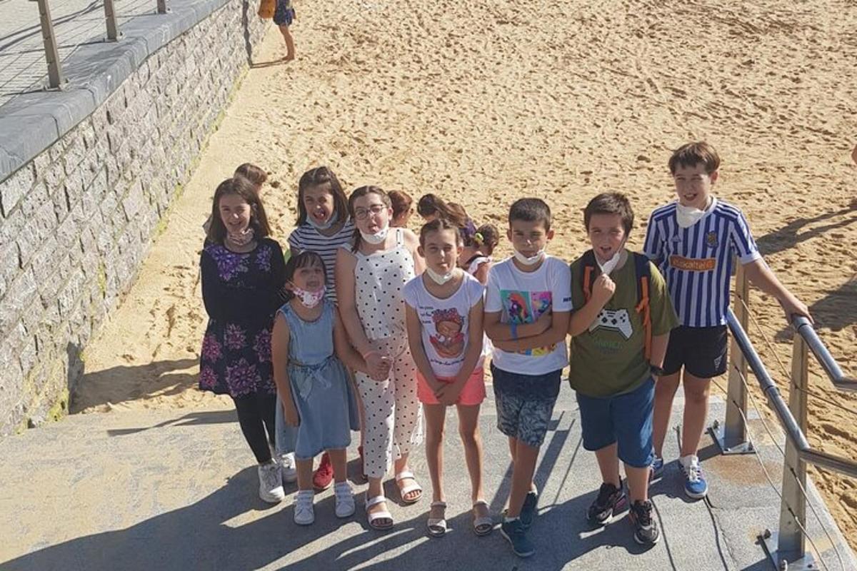 um grupo de crianças posando para uma foto na praia