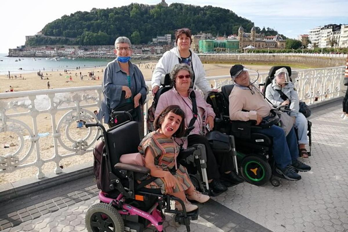 eine Gruppe von Menschen im Rollstuhl am Strand