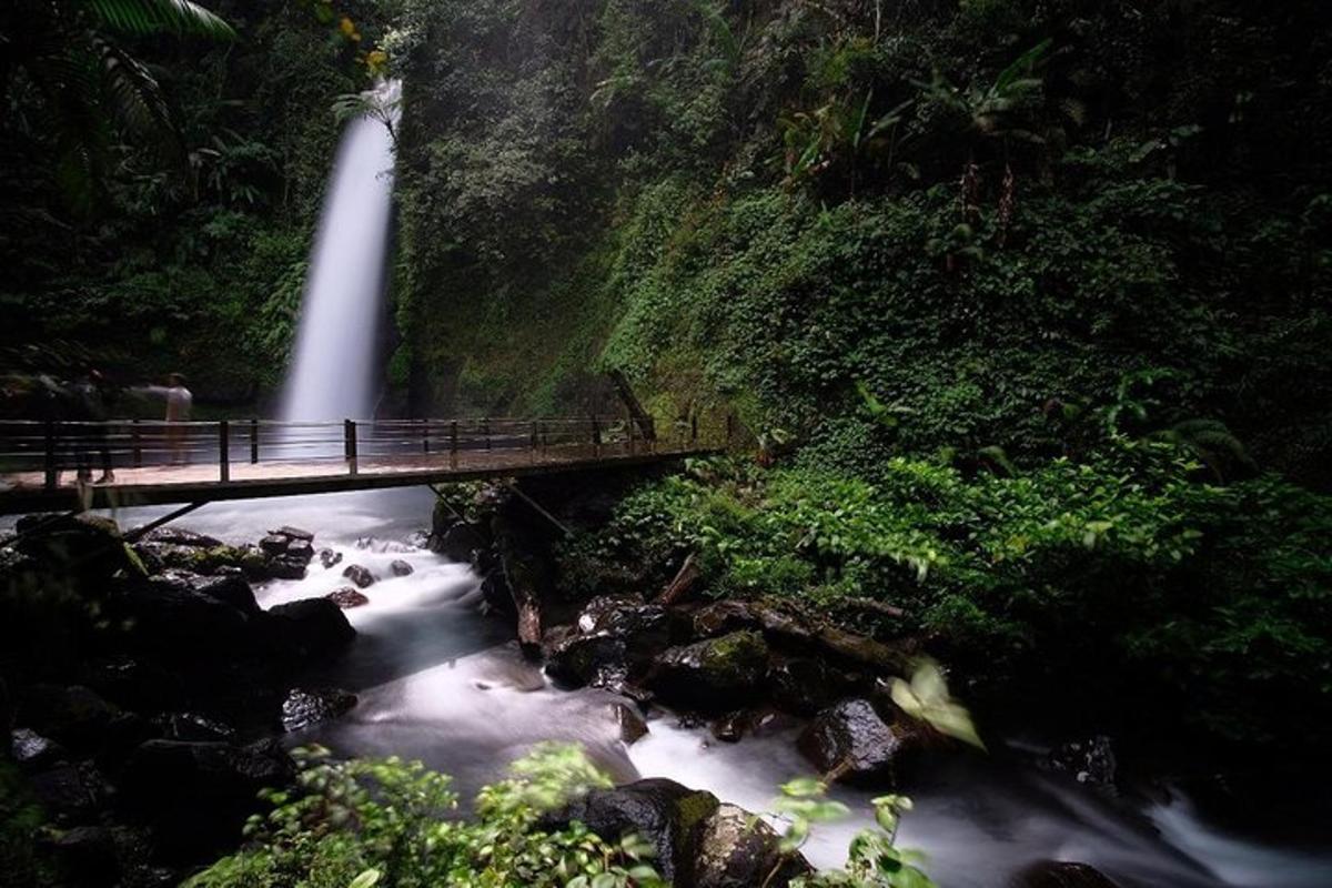 a waterfall and a bridge over a river with a waterfall
