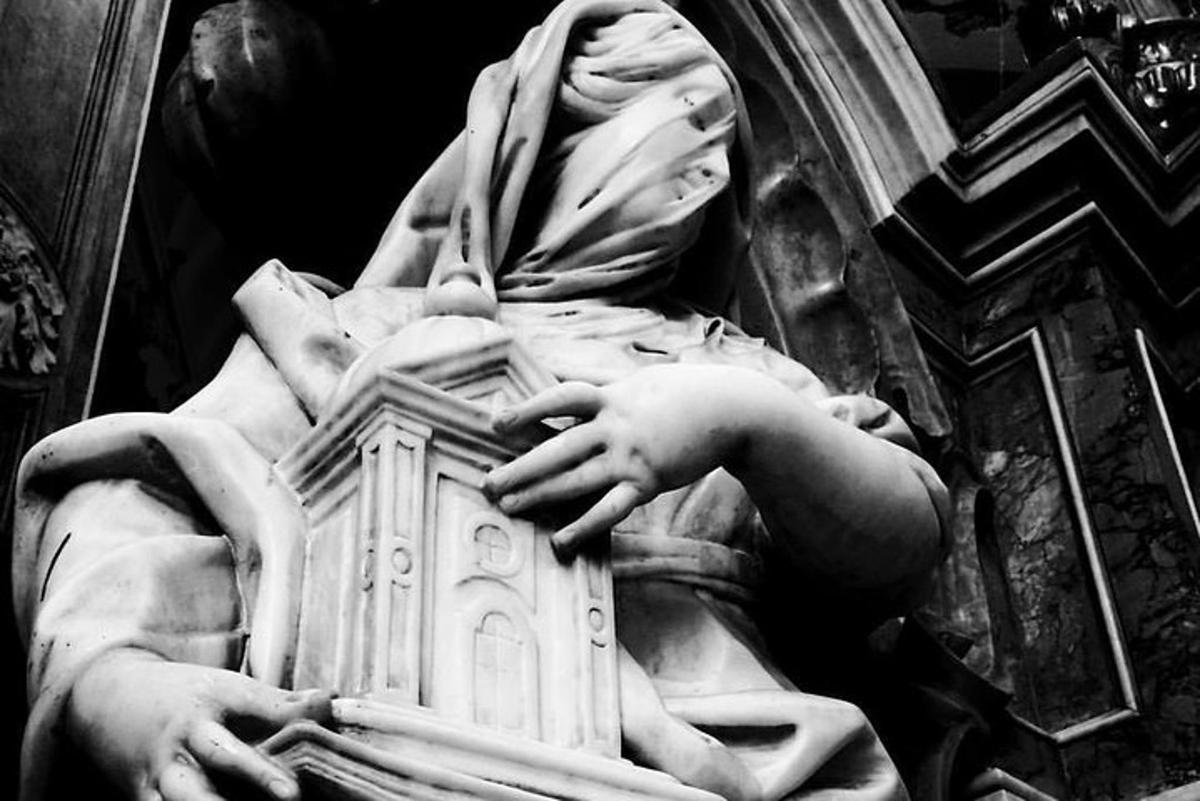Una estatua de una mujer sosteniendo un edificio.