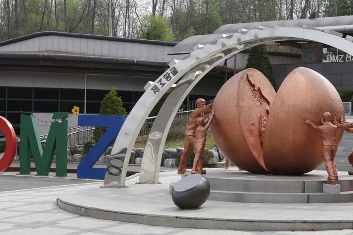 a statue of two men standing under a metal arch