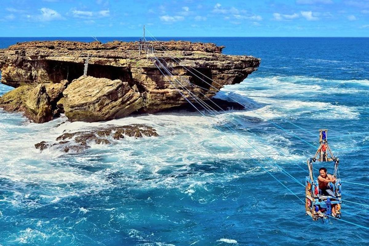 un uomo su un'altalena nell'acqua vicino a una scogliera
