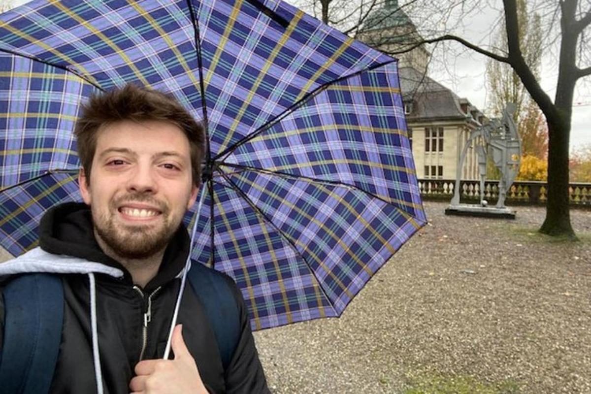 a man is holding a plaid umbrella