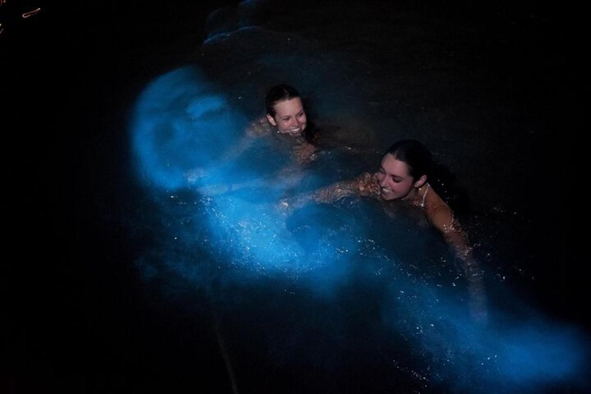 Dos hombres están en el agua con humo azul.