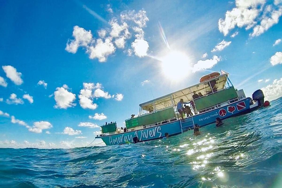 a boat in the ocean with the sun in the sky