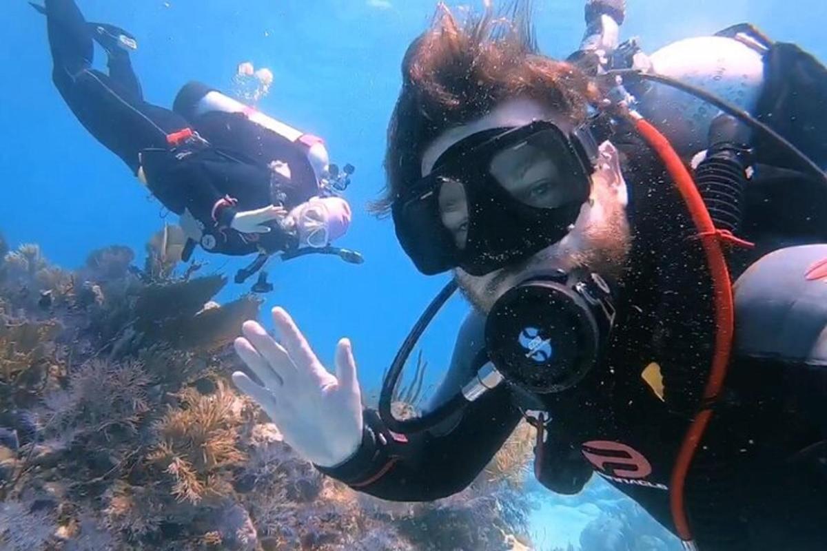 a woman in a diving suit and goggles swimming in the ocean
