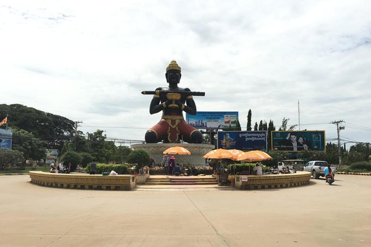 uma grande estátua em um estacionamento com uma grande estátua