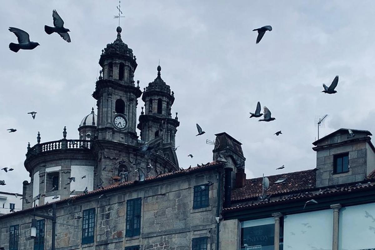 a flock of birds flying around a building with a clock tower