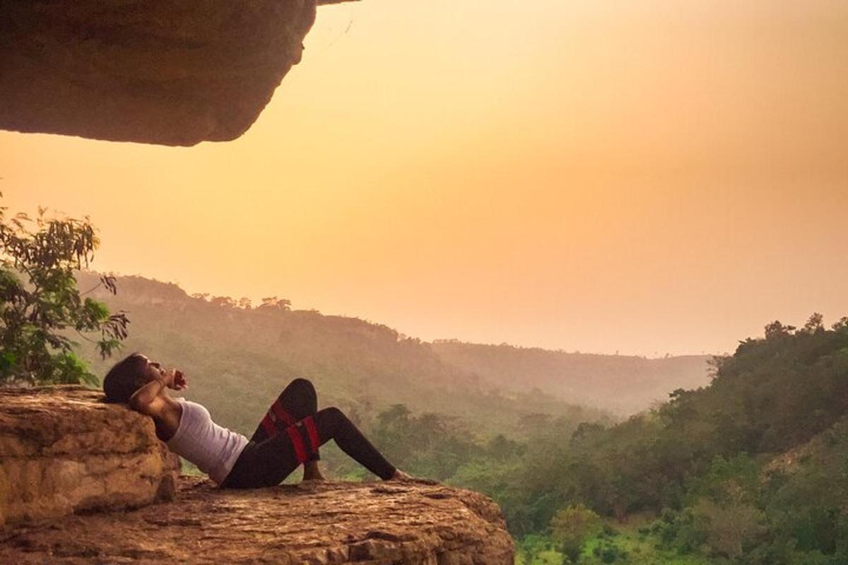 a person sitting on a rock looking out over a valley