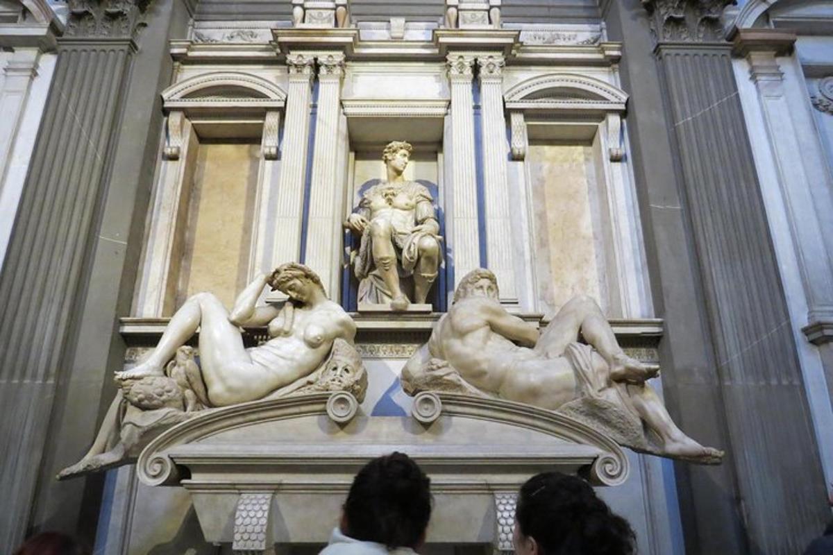 um grupo de pessoas em pé em frente a uma estátua