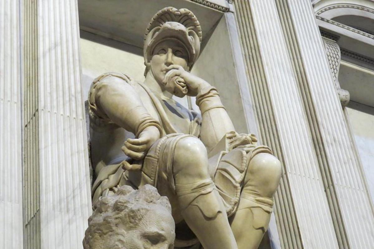 uma estátua de uma mulher sentada na lateral de um prédio