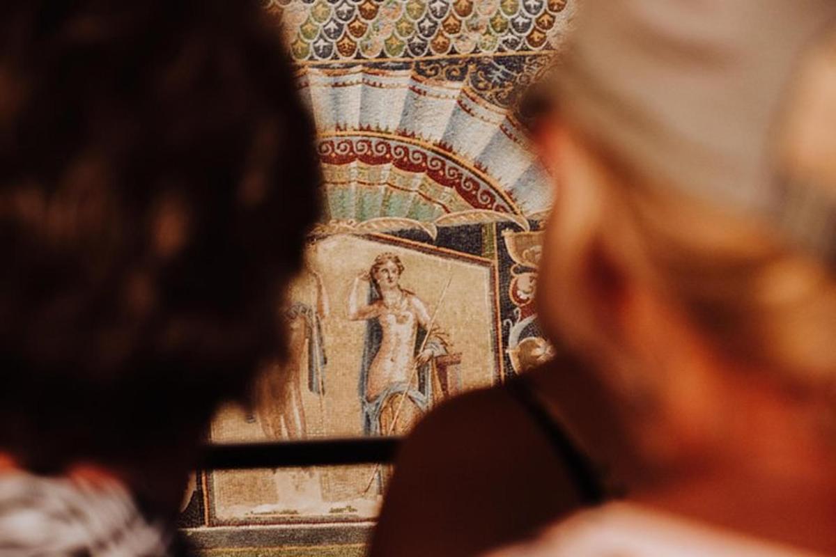 a group of people looking at a painting on a wall