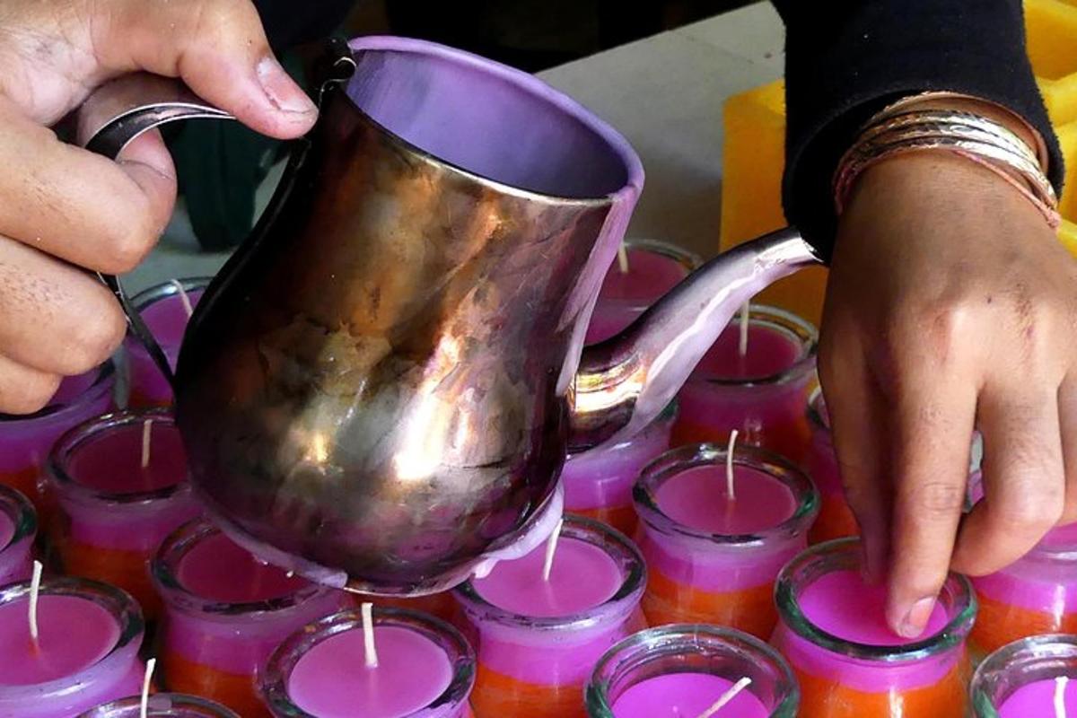 شخص يحمل إبريق شاي فوق مجموعة من الأكواب