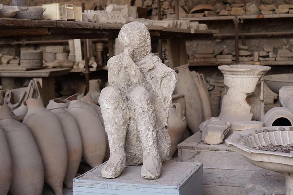 a statue of a person sitting inront of vases