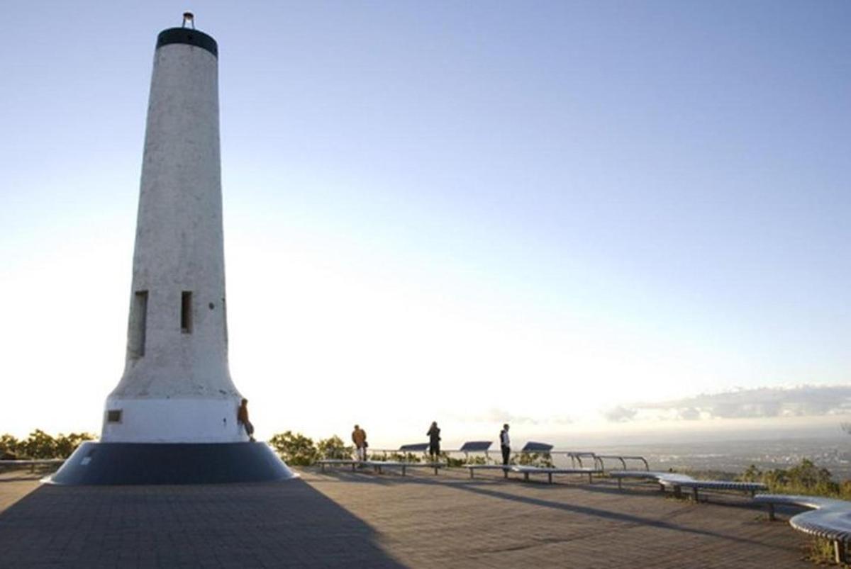 svetilnik na plaži, ob katerem stojijo ljudje
