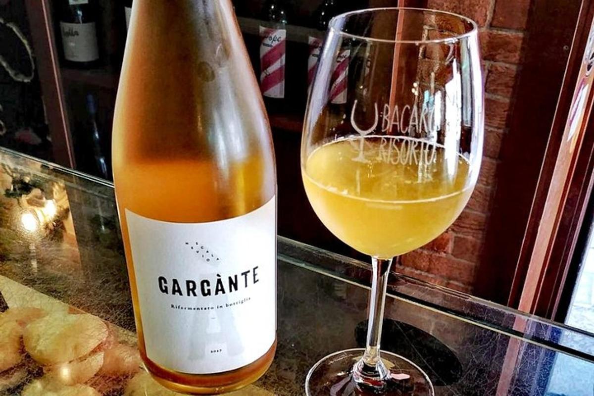 o sticlă de vin lângă un pahar de vin