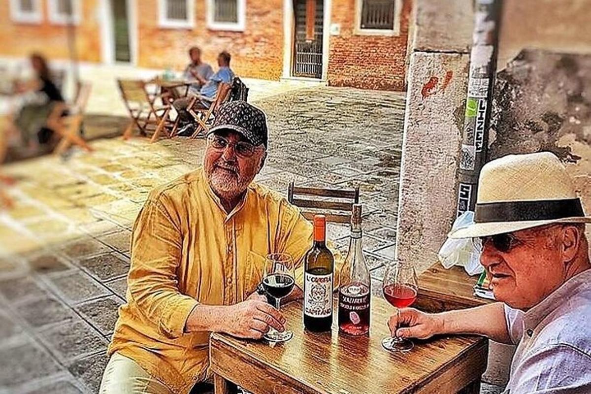 două persoane așezate la o masă cu pahare de vin