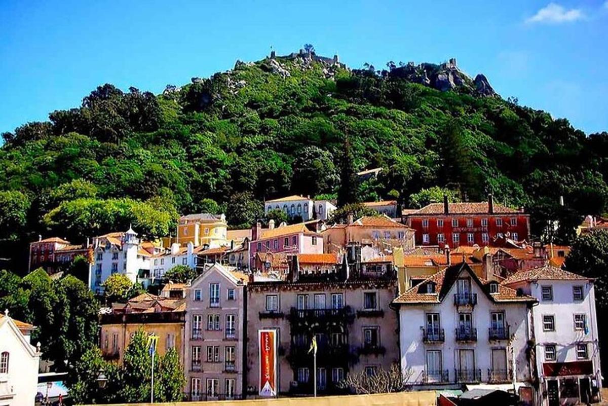 un pueblo en una colina con una montaña al fondo