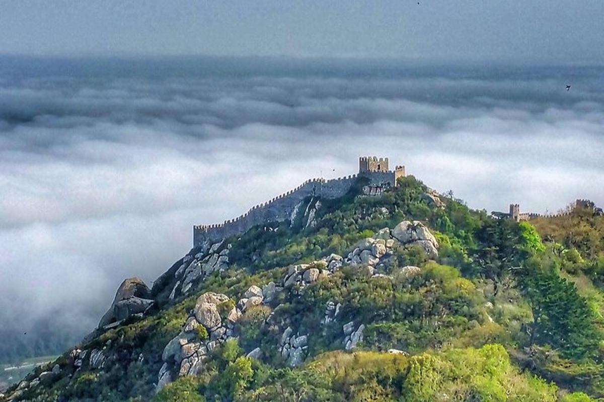 un castillo en la cima de una montaña en las nubes