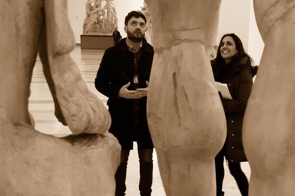 un uomo e una donna in piedi accanto a una statua