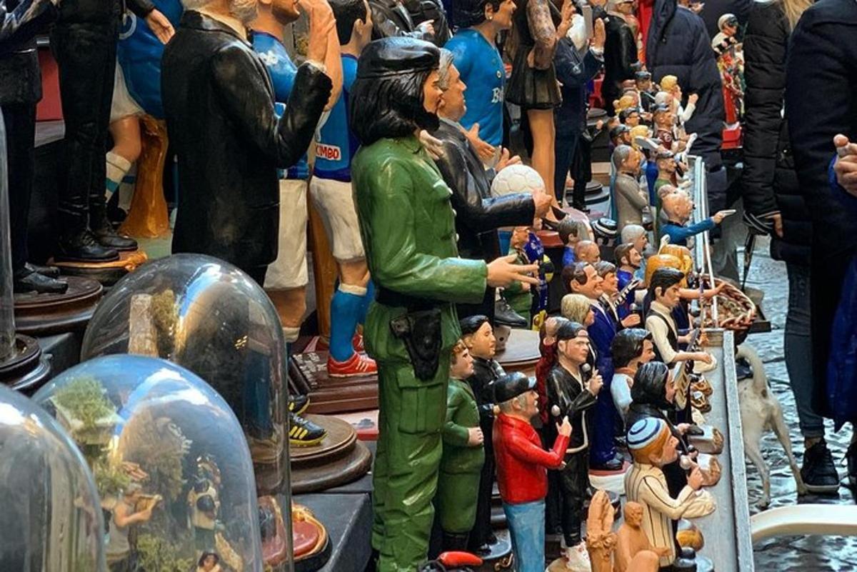un gruppo di persone che guarda la statua di un uomo in mezzo alla folla