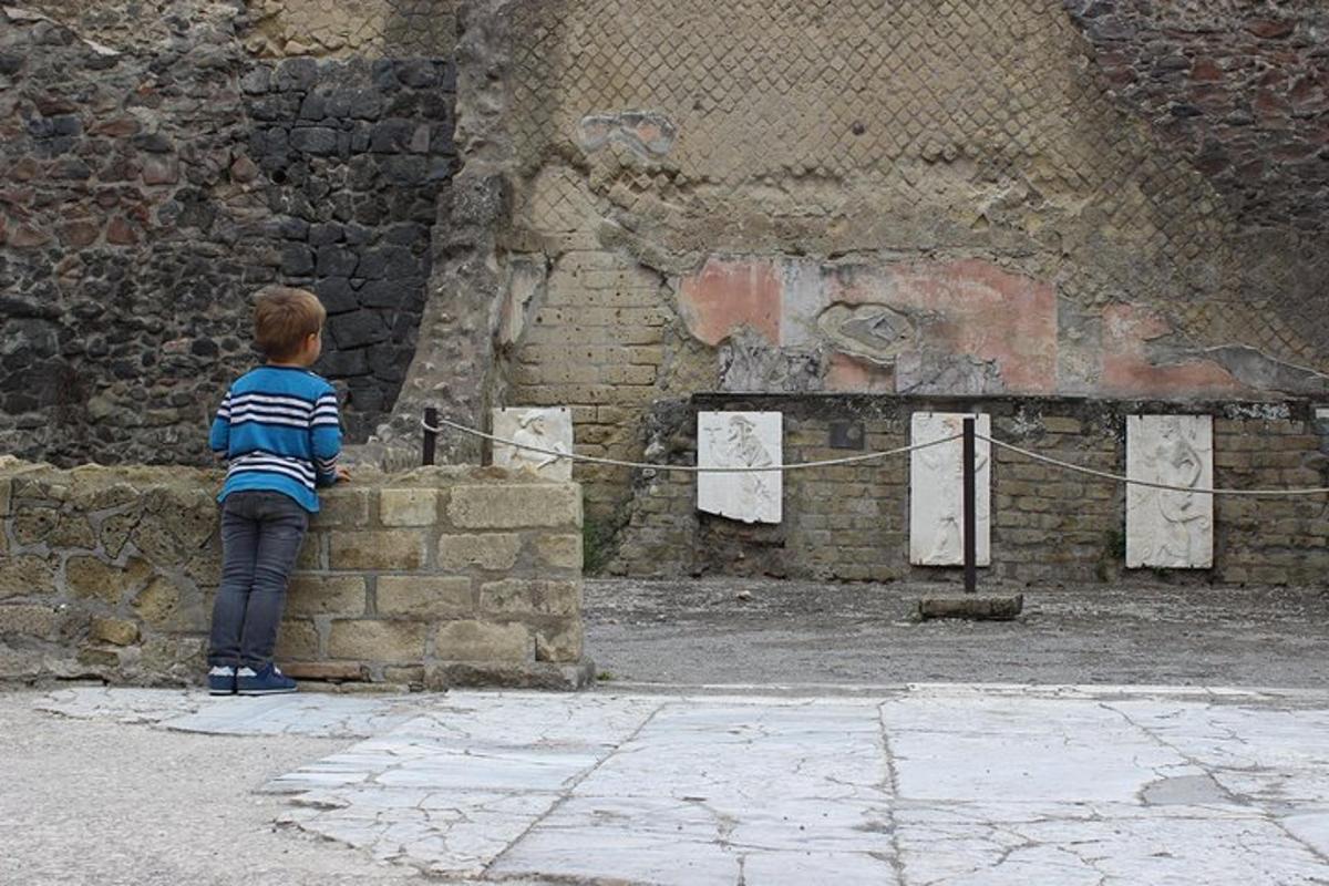 a little boy is standing on a wall
