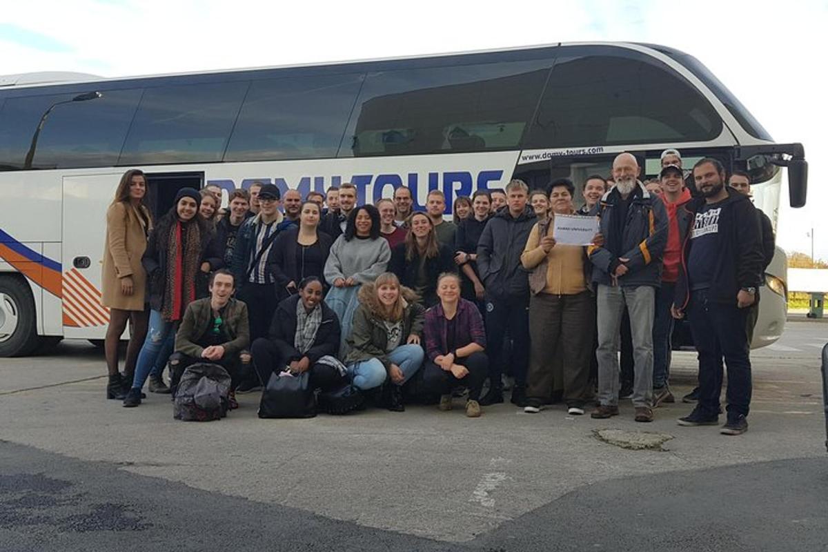 un gruppo di persone in piedi davanti a un autobus