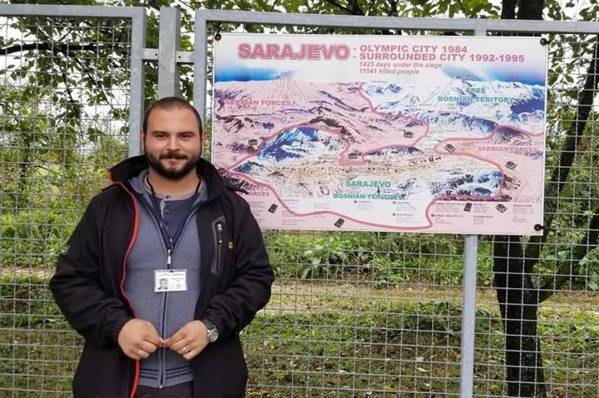un uomo in piedi davanti a un cartello