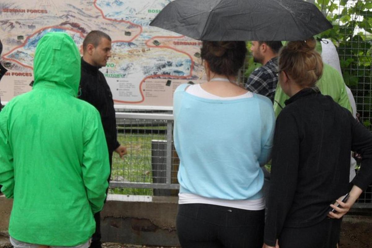 un gruppo di persone in piedi sotto un ombrello