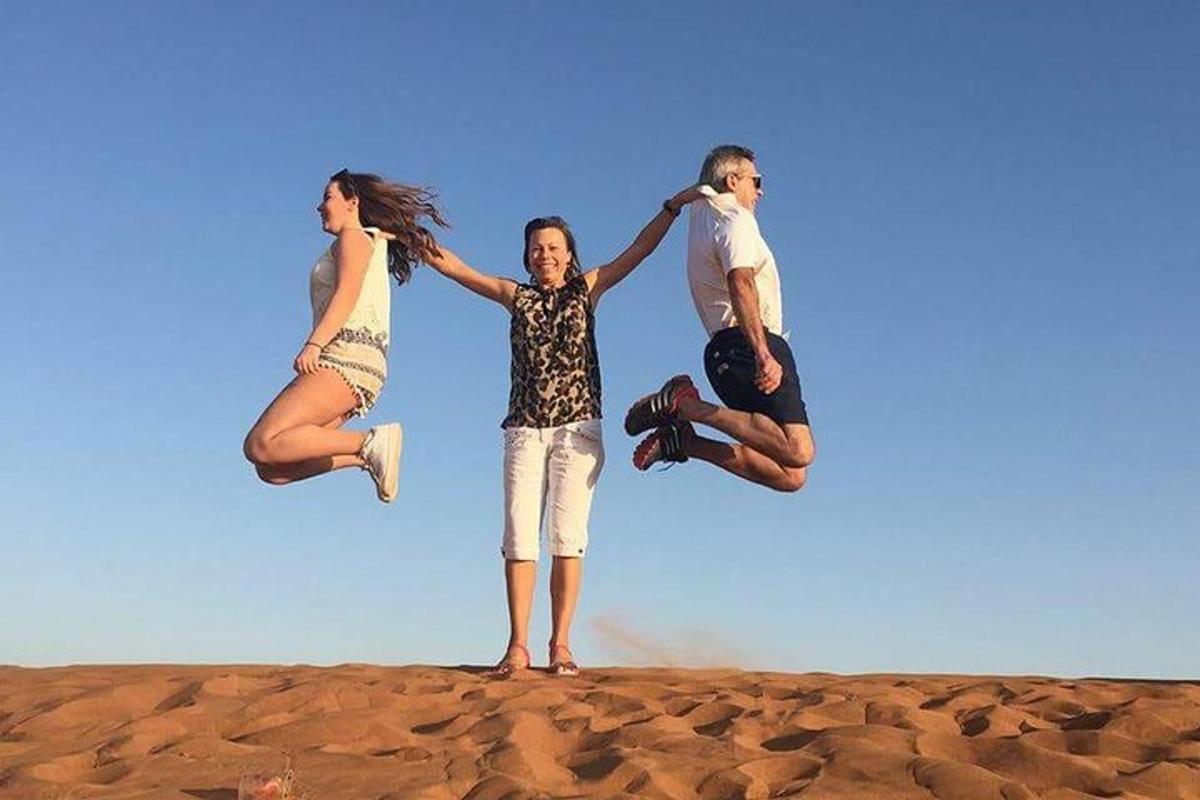 um grupo de quatro pessoas pulando na praia
