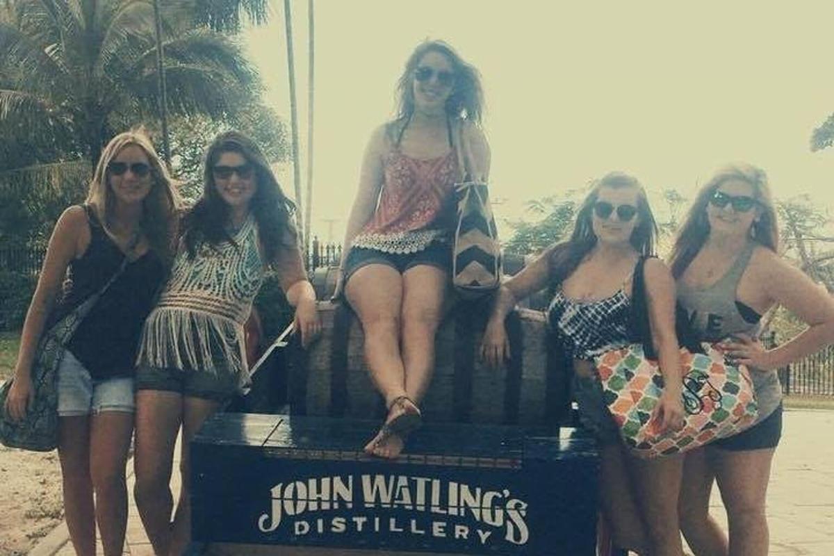 a group of women sitting on a sign on the beach