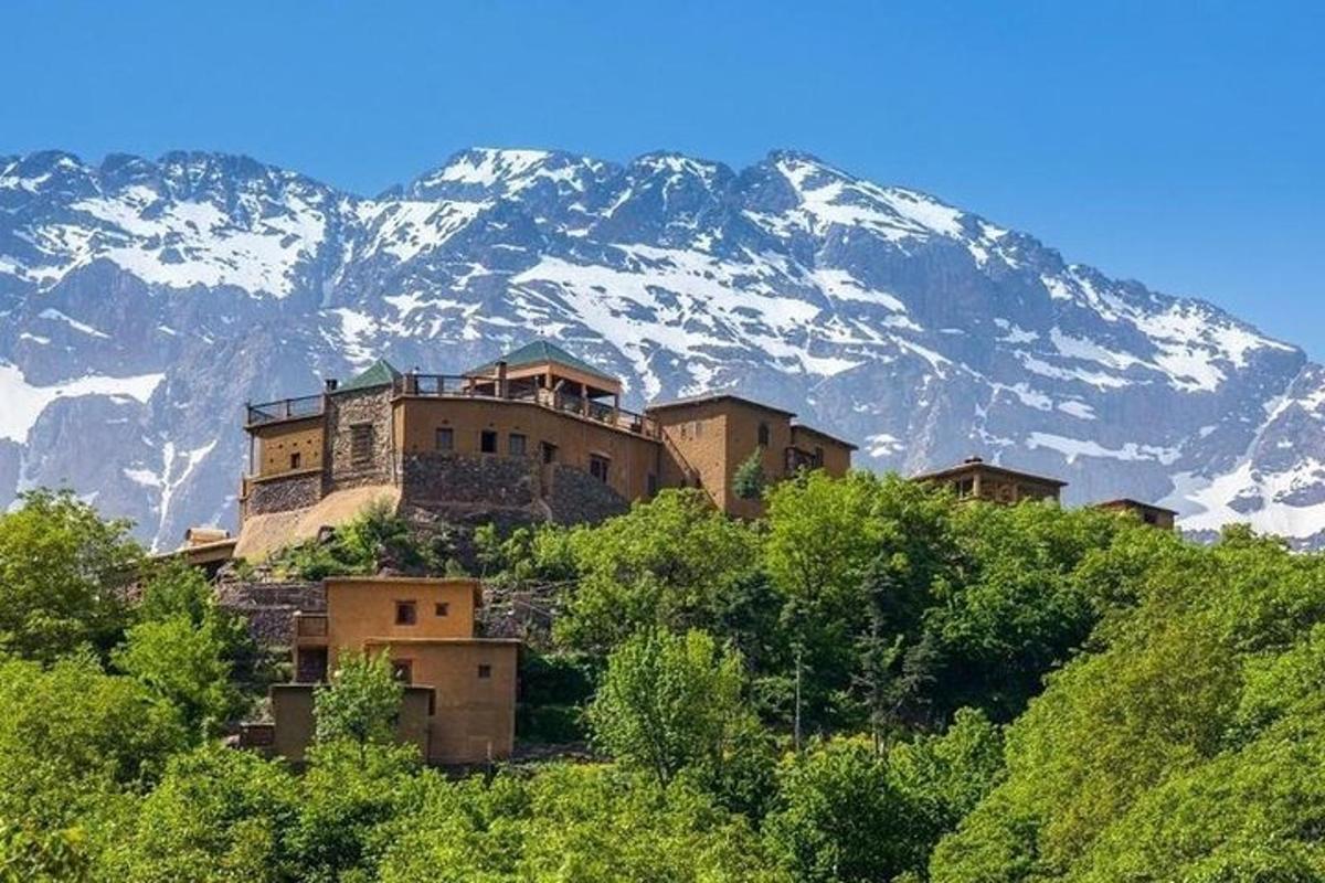 Un edificio en la cima de una colina con una montaña cubierta de nieve.