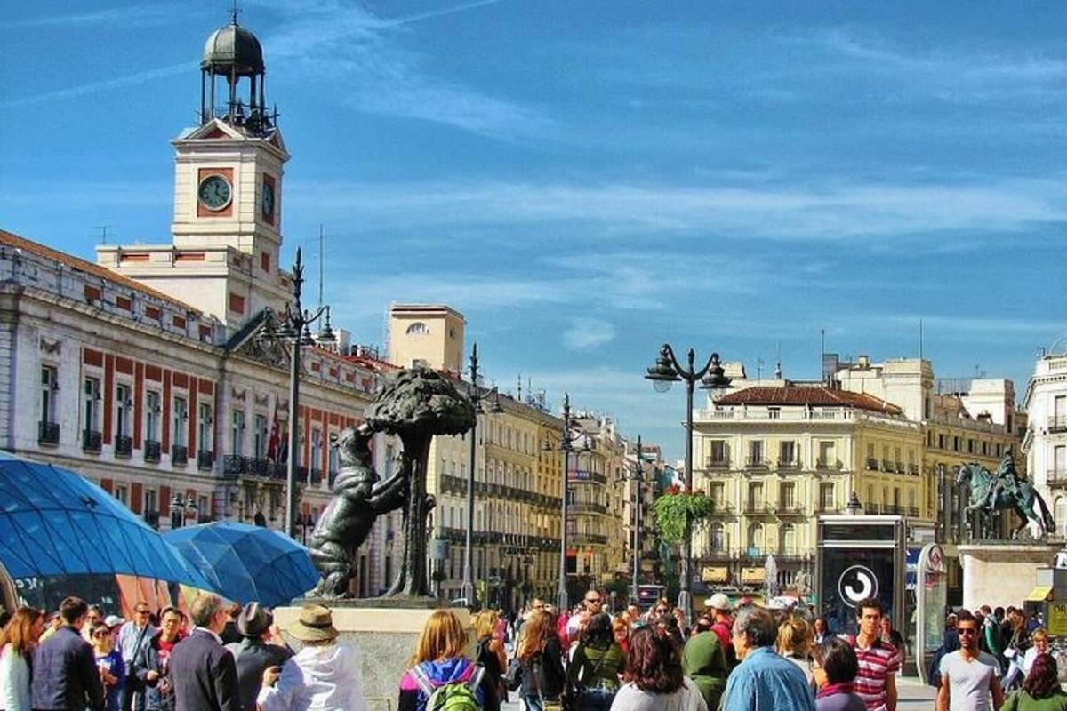 o mulțime de oameni care se plimbă într-un oraș cu un turn cu ceas