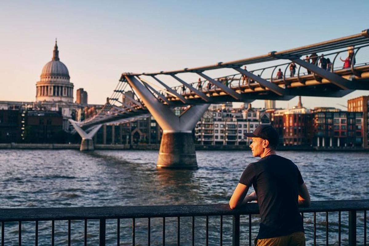 a man standing next to a bridge next to the water