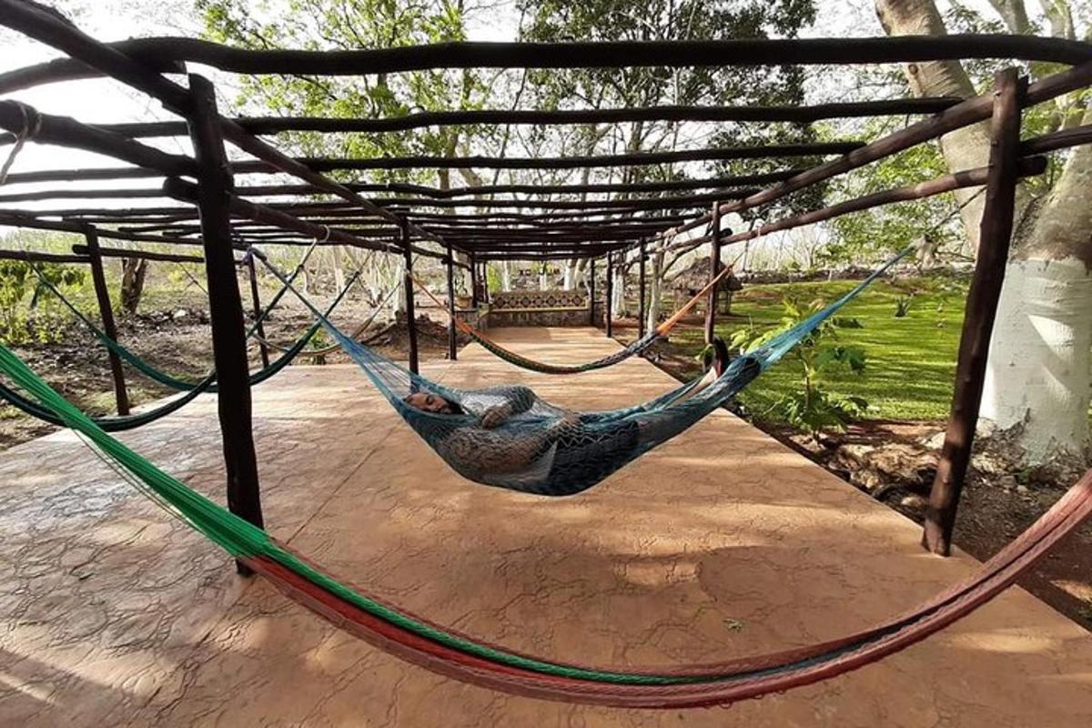 vīrietis guļ šūpuļtīklā parkā