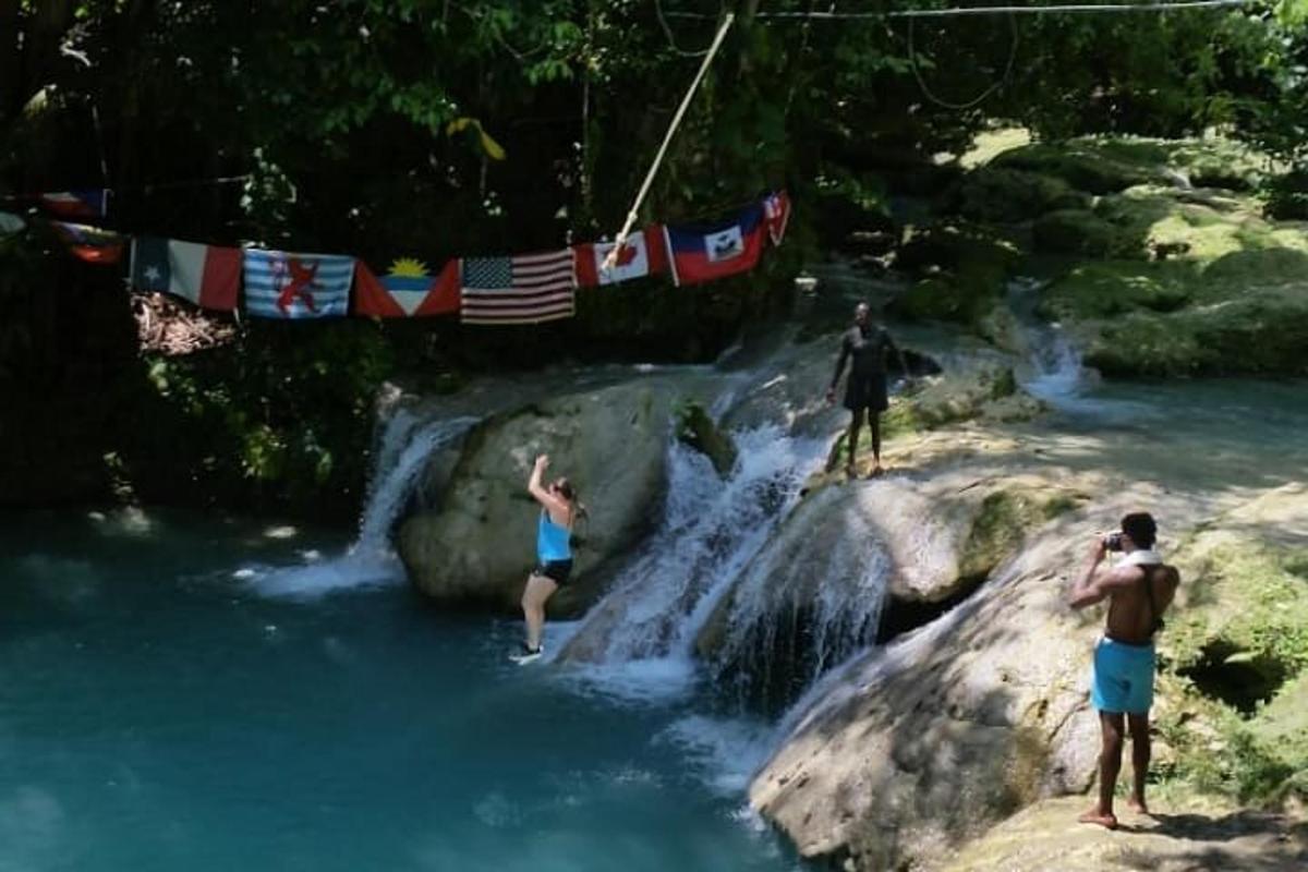 isang grupo ng mga tao na nakatayo sa mga bato sa isang ilog